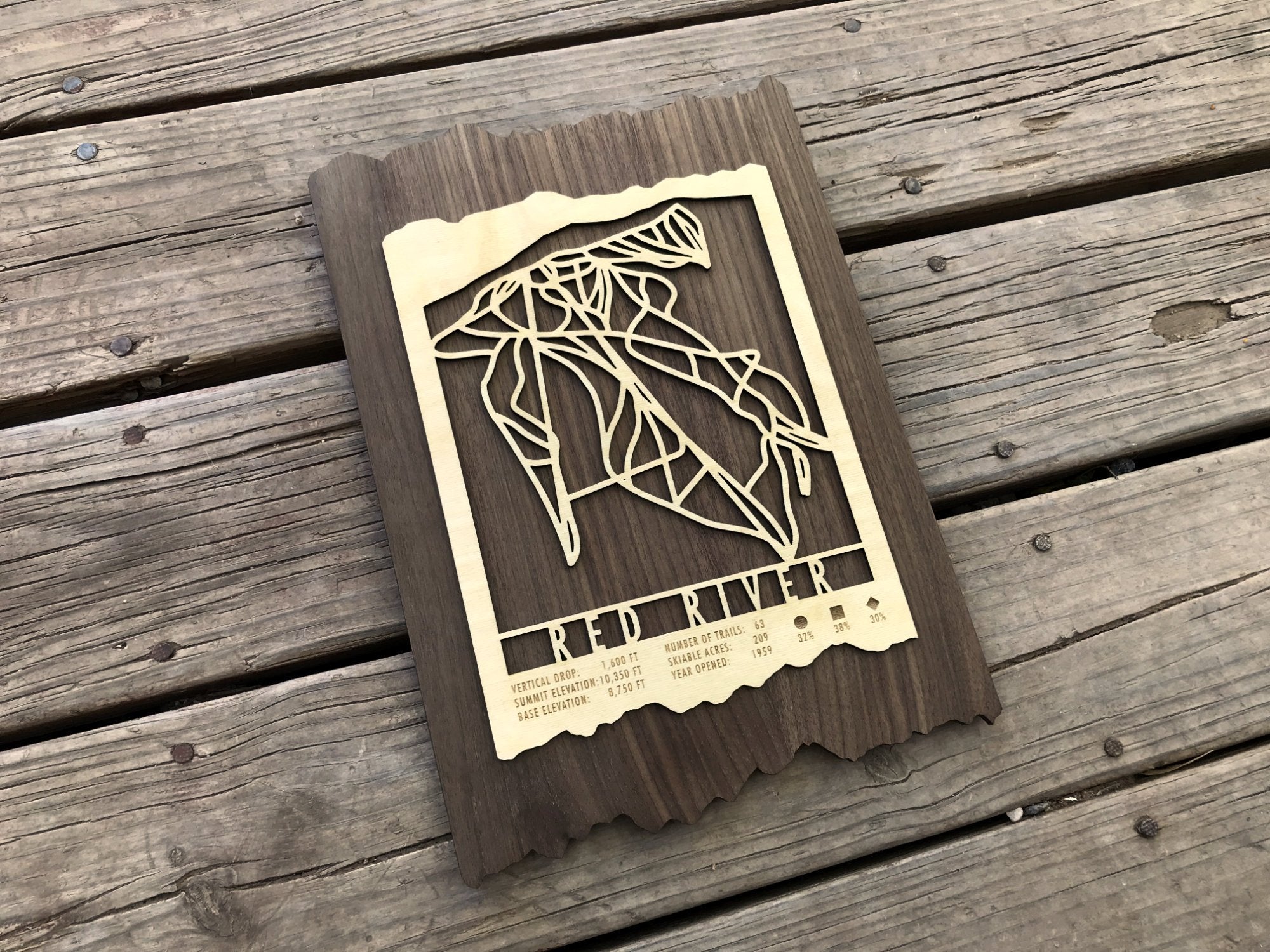 Angled view of Red River Ski Trail Map - Wood Ski Decor showing detailed ski trail cutouts on dark wood, perfect for ski-themed interior design.