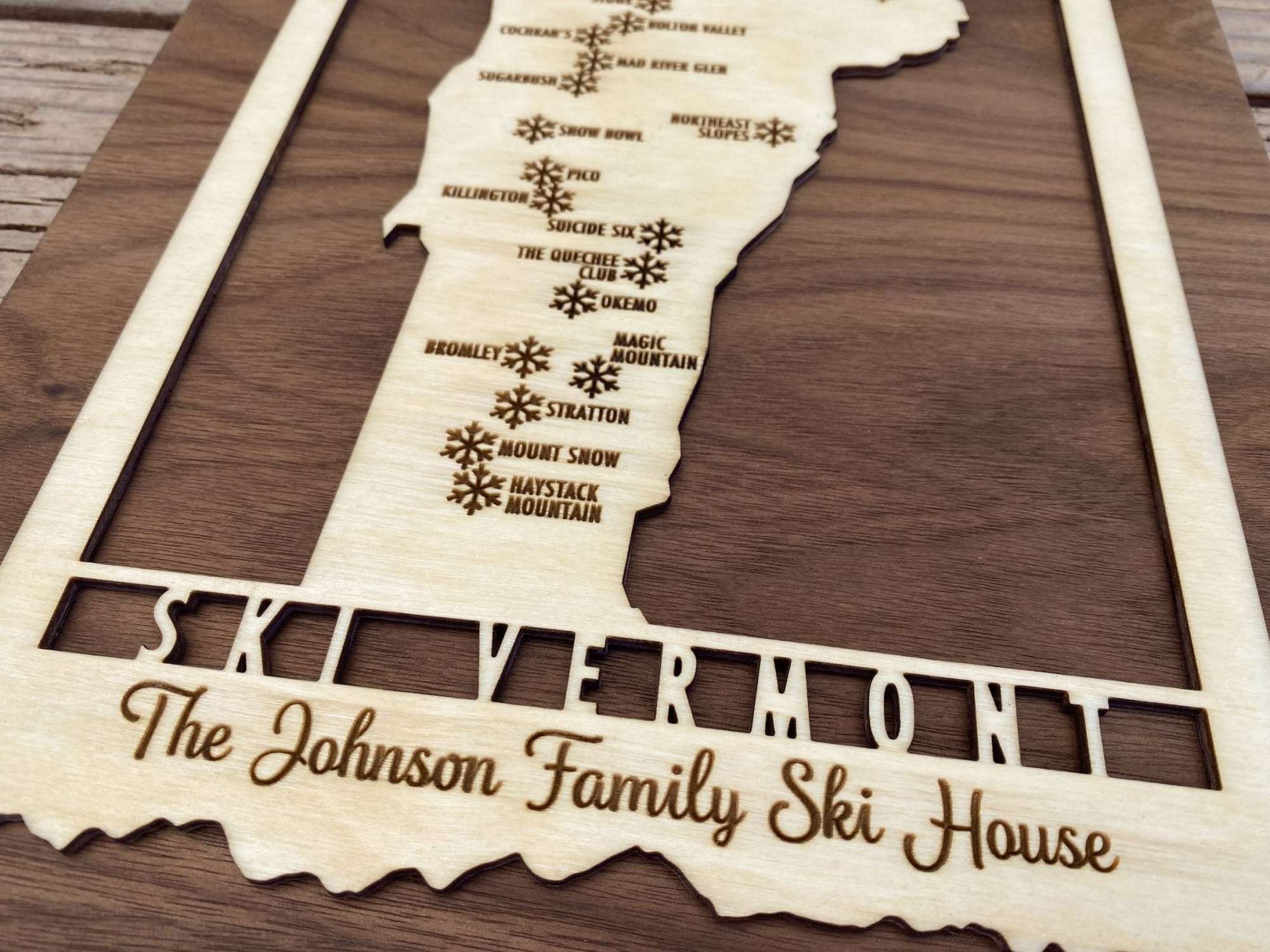 Close-up of custom engraved Ski Vermont wood map with personalized text, showcasing detailed ski resort names.