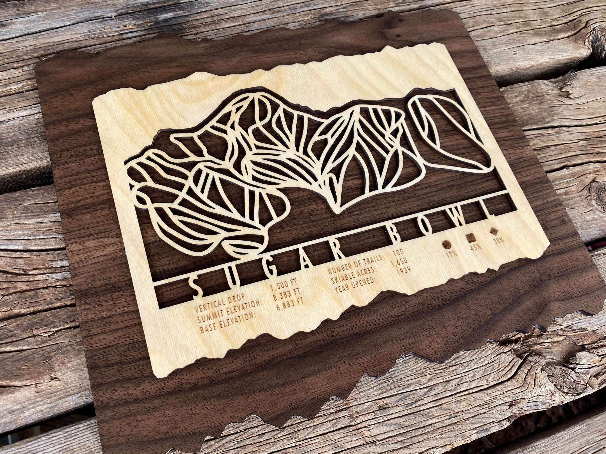 Close-up angled view of Sugar Bowl Ski Trail Map wood wall art showing detailed mountain trails and engraved resort information.