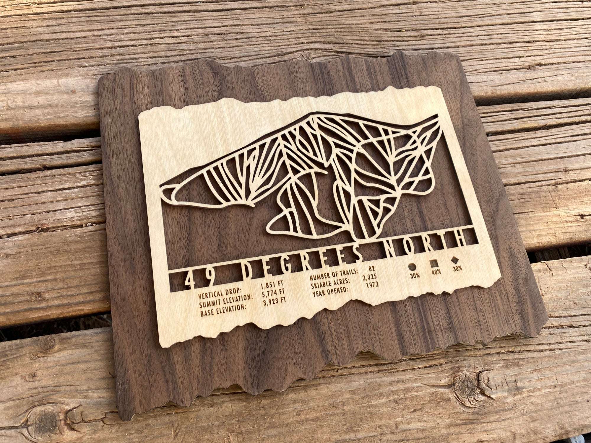 Rustic 49 Degrees North Ski Trail Map wood decor placed on wooden surface, perfect mountain-themed artwork for home or cabin.