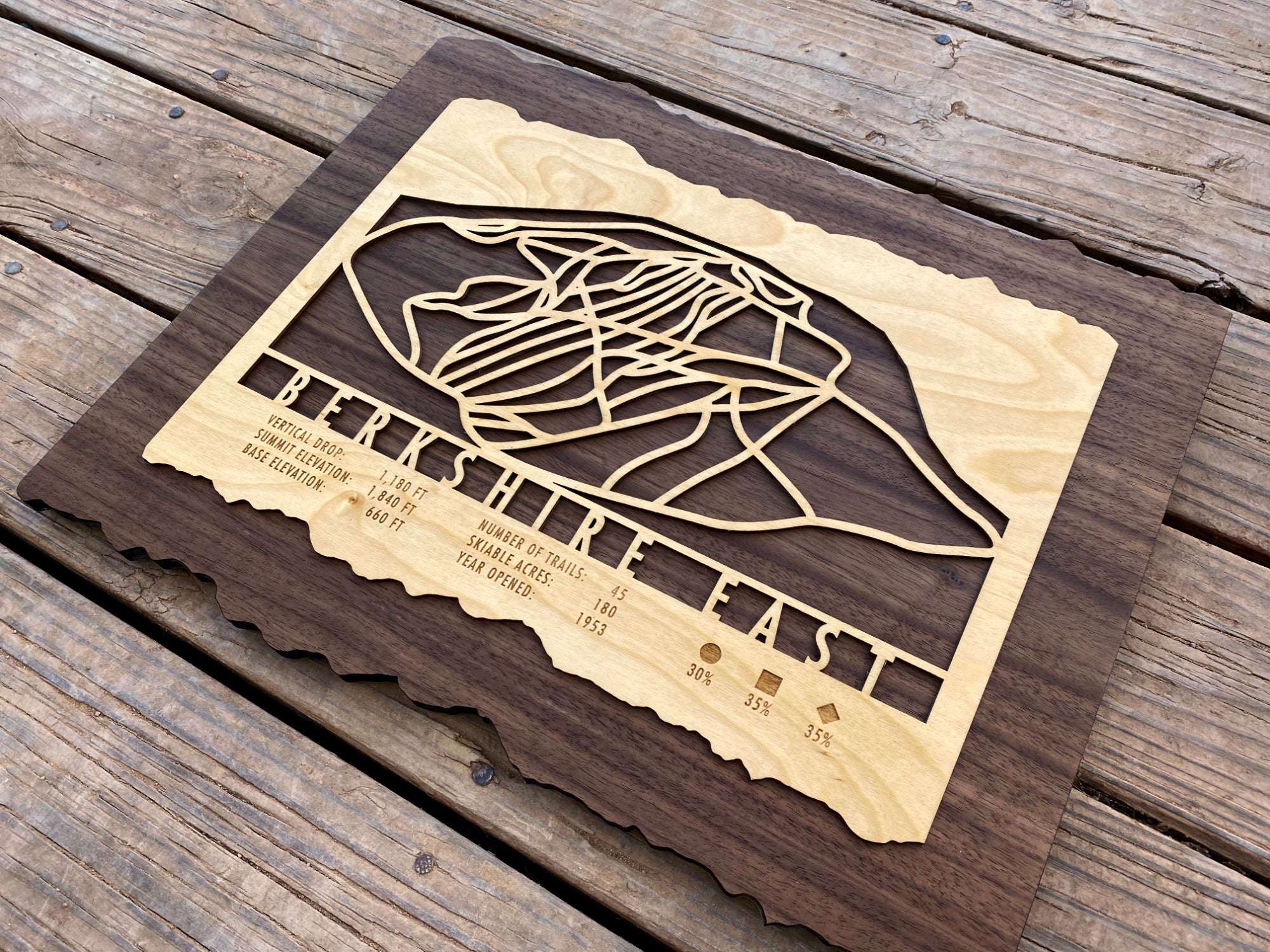 Angled view of Berkshire East Ski Trail Map, highlighting intricate trail carvings and natural wood grain.
