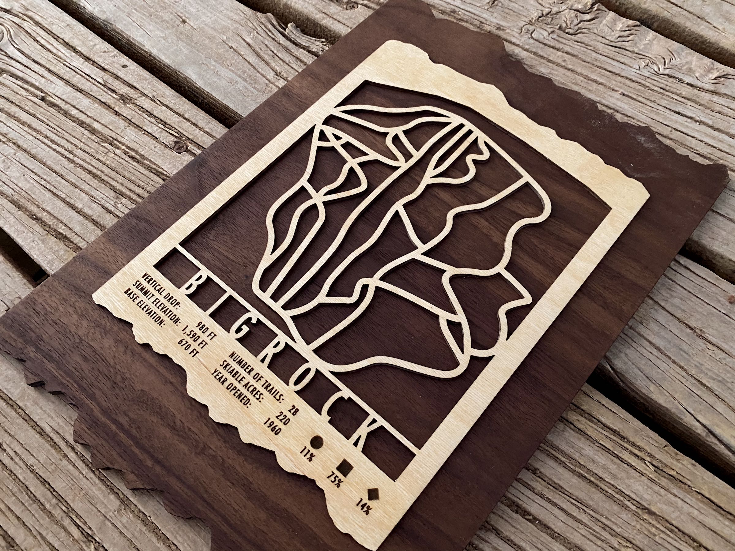Angled view of Bigrock Mountain Ski Trail Map - Wood Ski Decor with detailed trail layout and engraved resort information on dark wood.