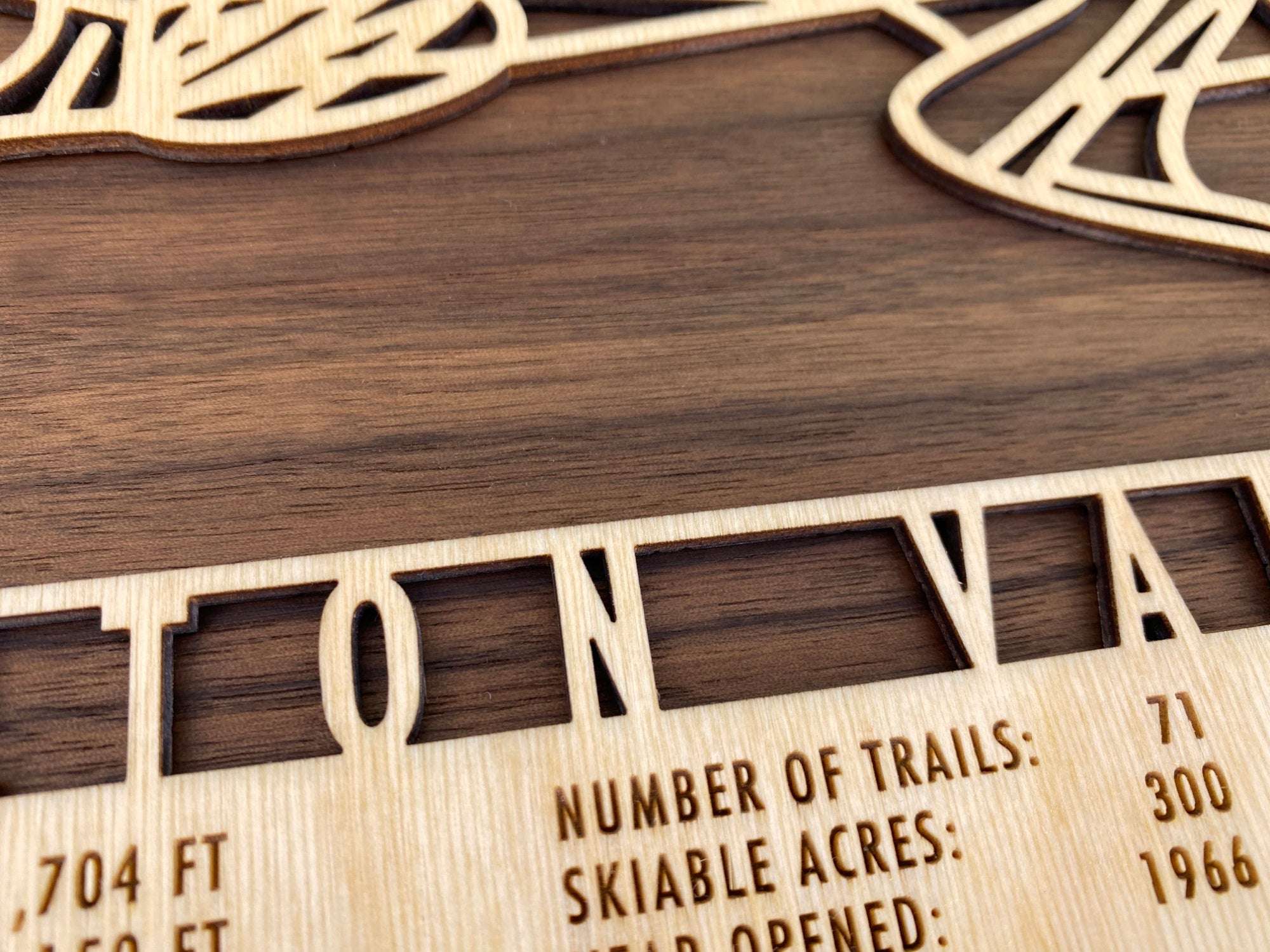 Close-up of Bolton Valley Trail Map - Wall Decor - Mountaincut showing detailed laser engraving of trail names and resort statistics on wood.
