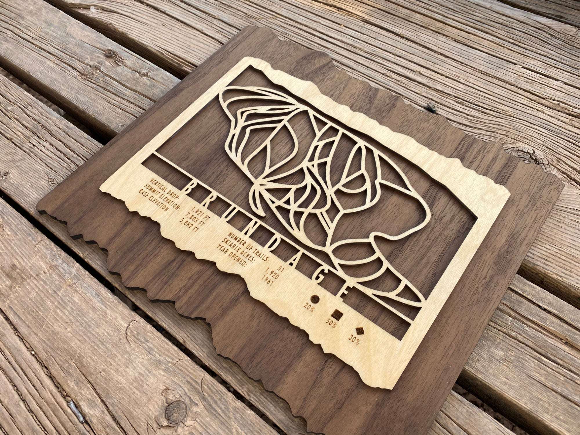 Brundage Ski Trail Map Wood Ski Decor by Mountaincut displayed on wood surface, highlighting intricate ski trail design and rustic craftsmanship.