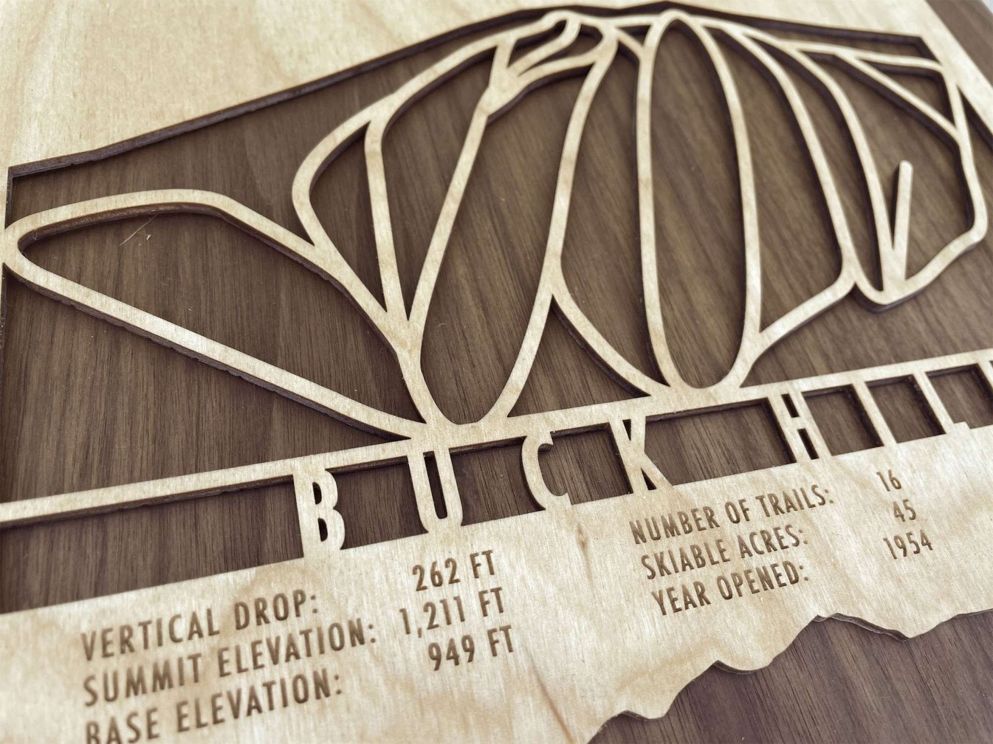 Detailed close-up of Buck Hill Ski Trail Map - Wall Decor - MountainCut showing engraved resort stats and precision-cut trail paths on wood.