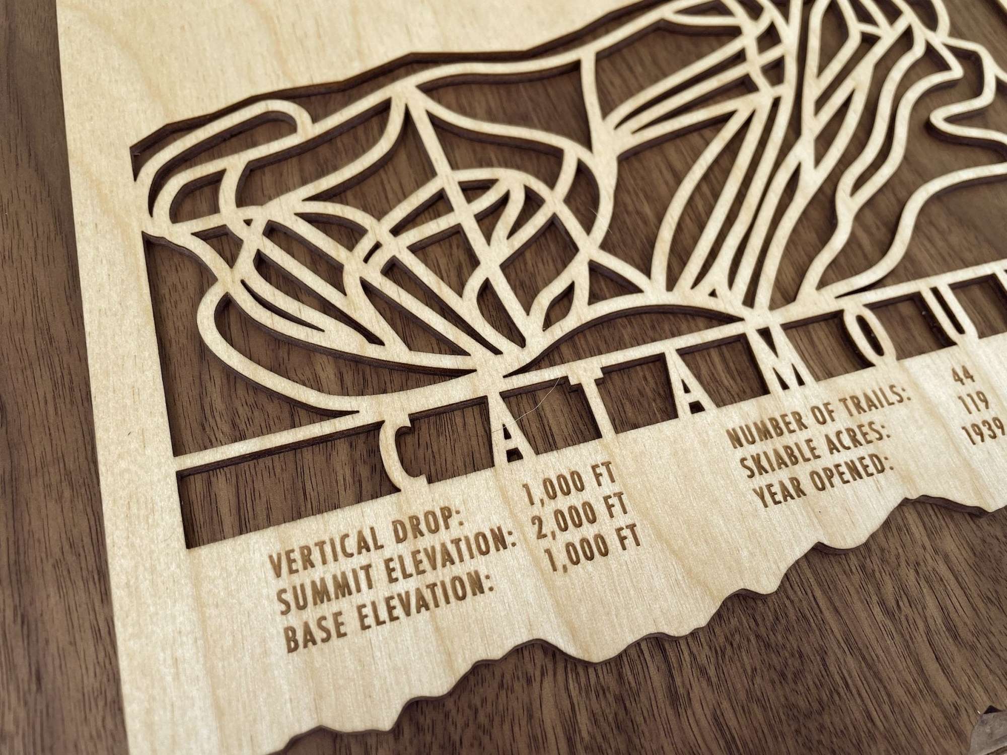 Close-up of Catamount Ski Trail Map wood art showing engraved vertical drop, elevation, and trail stats, ideal gift for skiers and snowboarders.