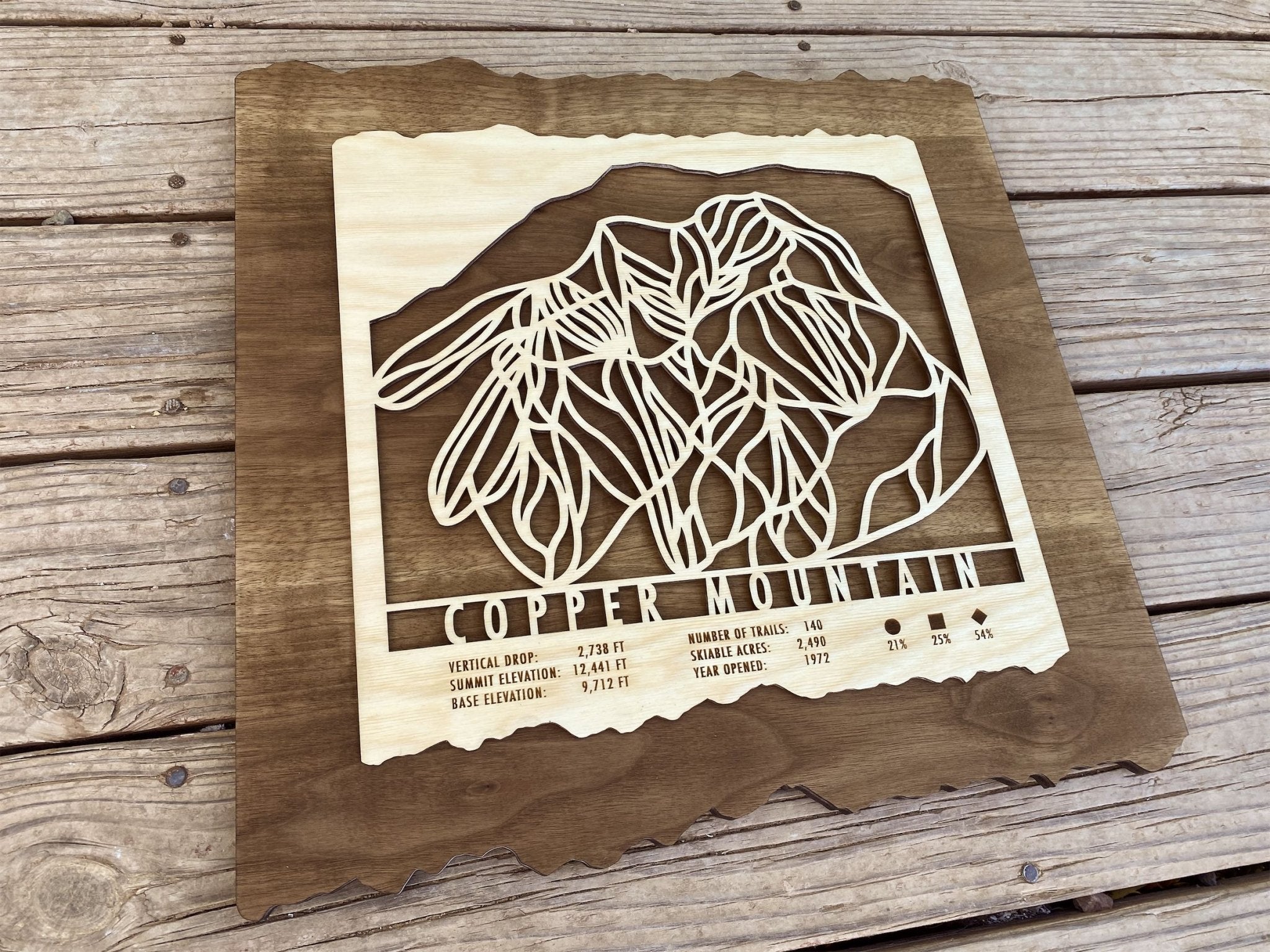 Angled view of Copper Mountain Ski Trail Map - Wood Wall Decor showing detailed ski trails and engraved mountain stats on natural wood.