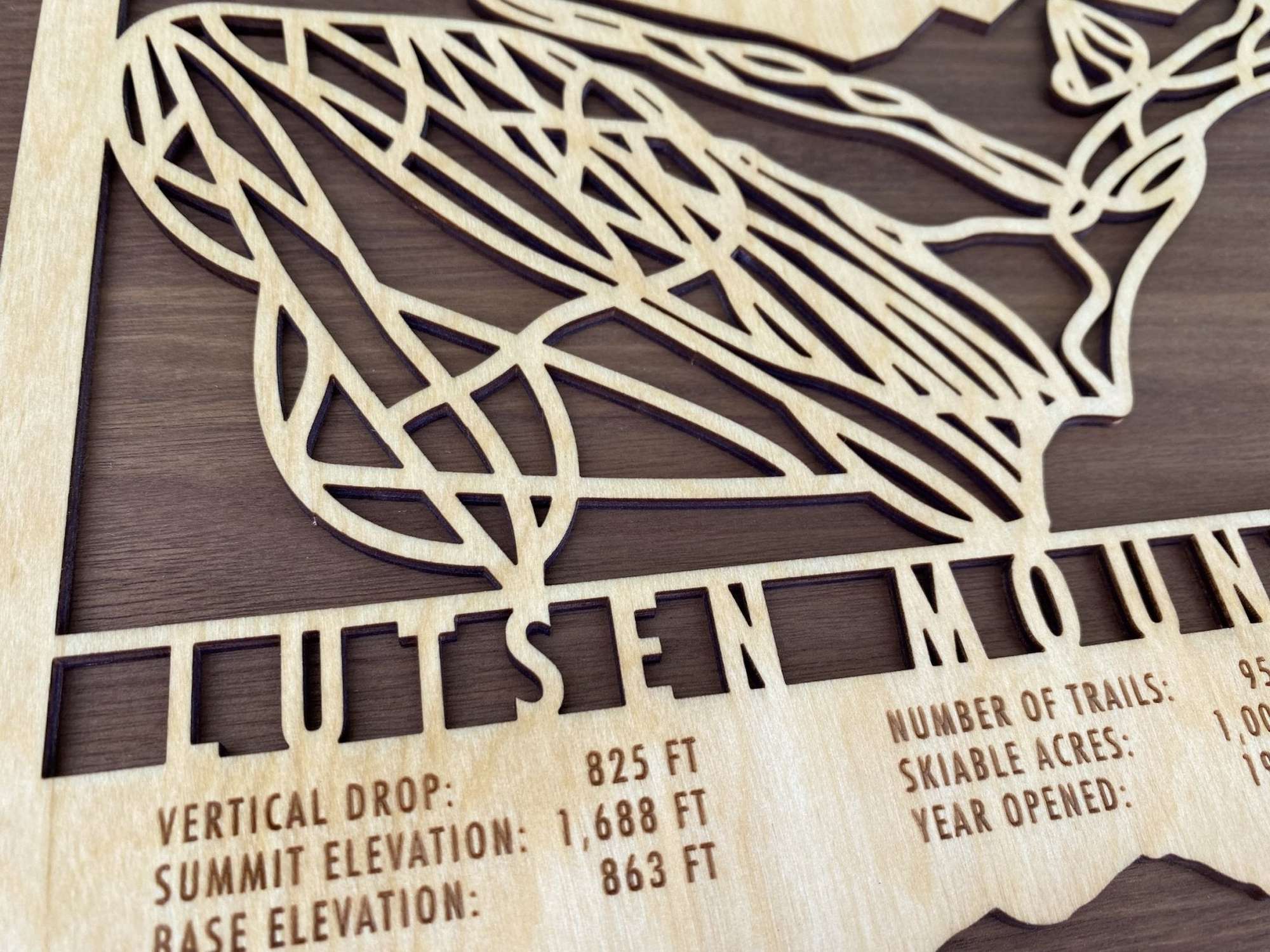Close-up of Lutsen Mountains wood ski trail map showing precise laser-cut details and engraved elevation and trail info.