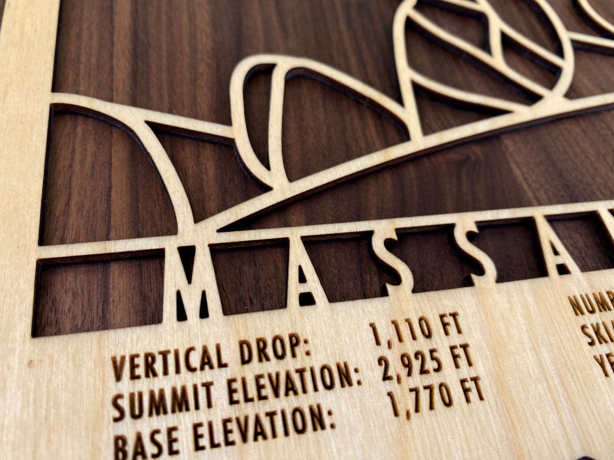 Close-up of Massanutten wood ski map showing engraved vertical drop, summit and base elevations, perfect for ski enthusiasts' wall display.