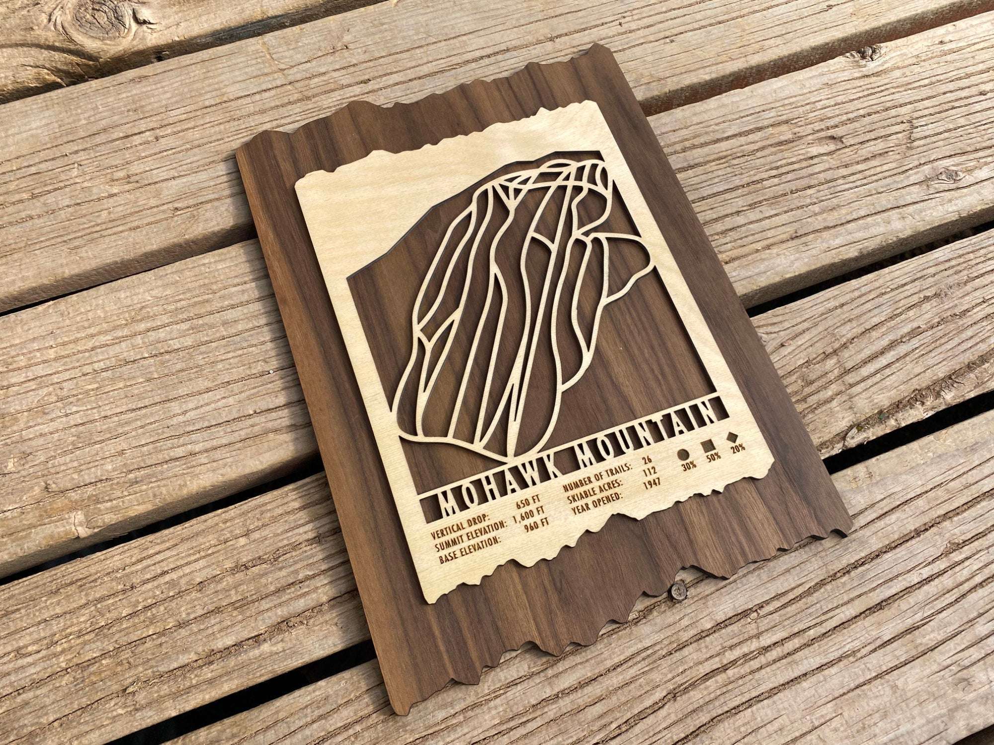 Angled view of Mohawk Mountain Ski Trail Map - Wood Ski Decor on rustic wood background, showcasing its laser-cut design and craftsmanship.