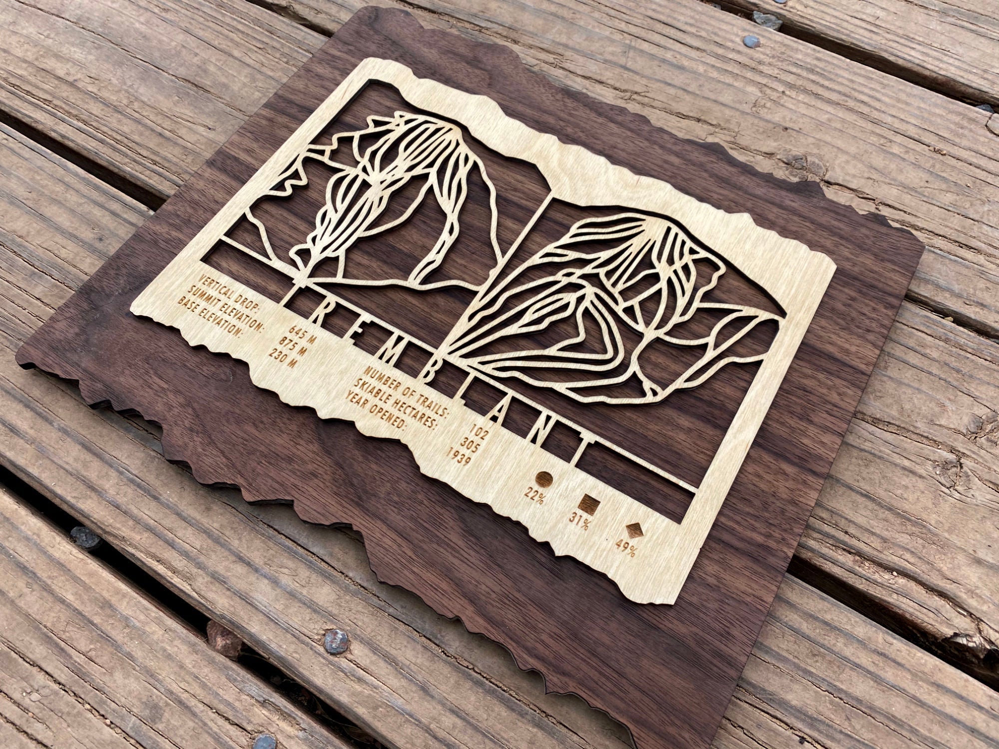 Side angle of Mont Tremblant ski trail map carved in wood, highlighting intricate trail design and rustic decor appeal.
