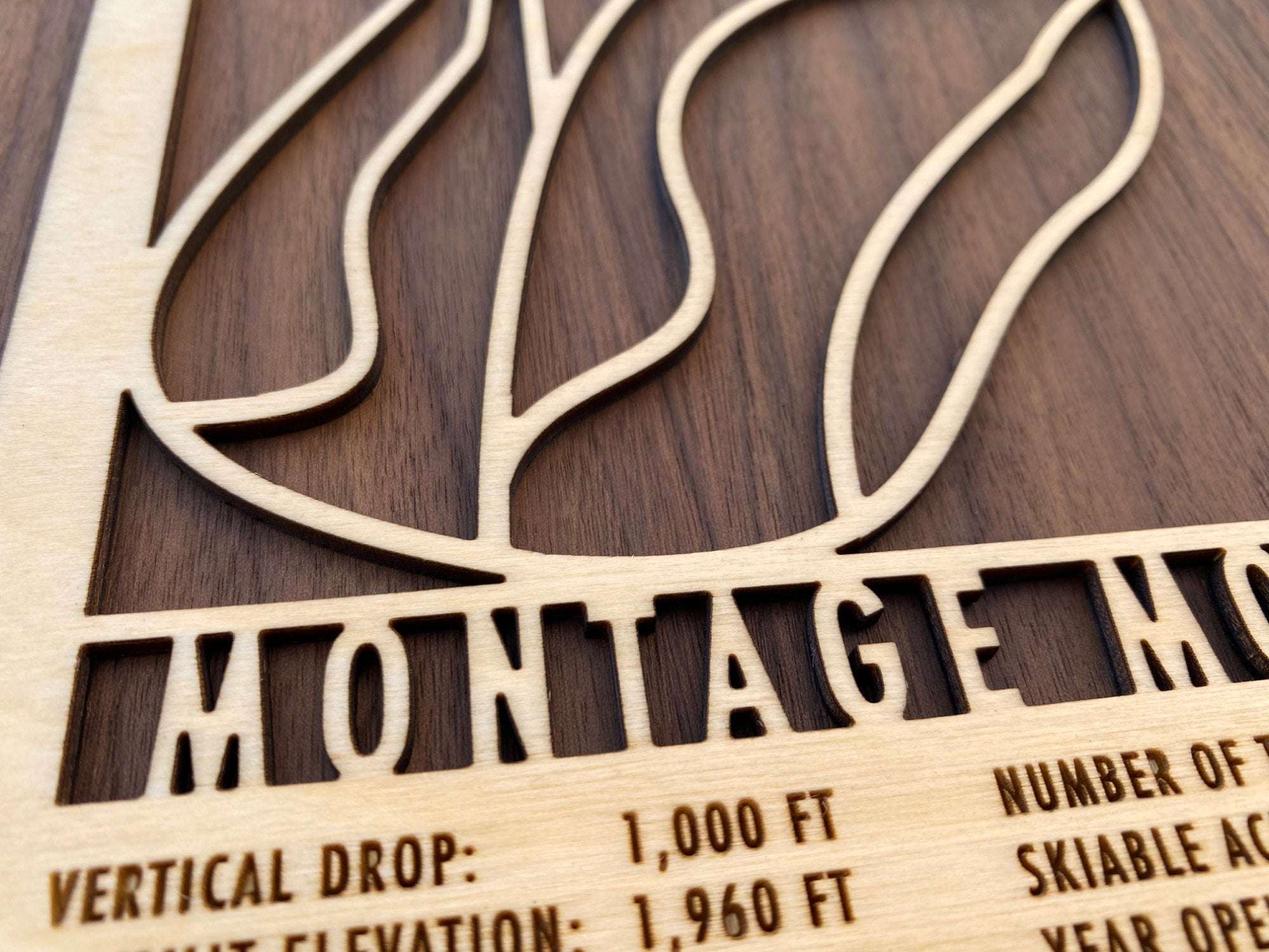 Close-up of Montage Mountain wood ski map showing precision laser-cut lettering and trail lines for rustic ski-themed home decor.