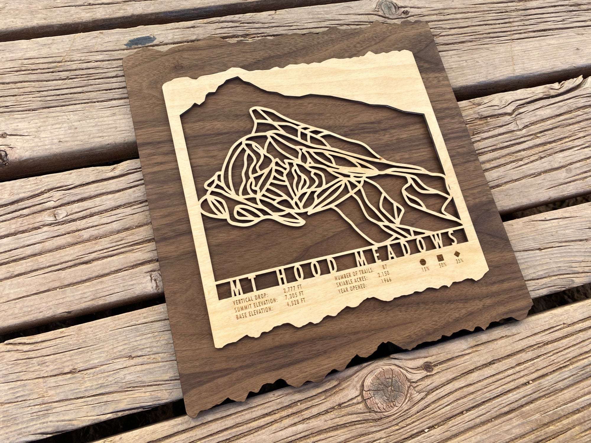 Wooden Mt Hood Meadows Ski Trail Map decor placed on rustic wood surface, showcasing detailed ski run carvings and natural wood grain.