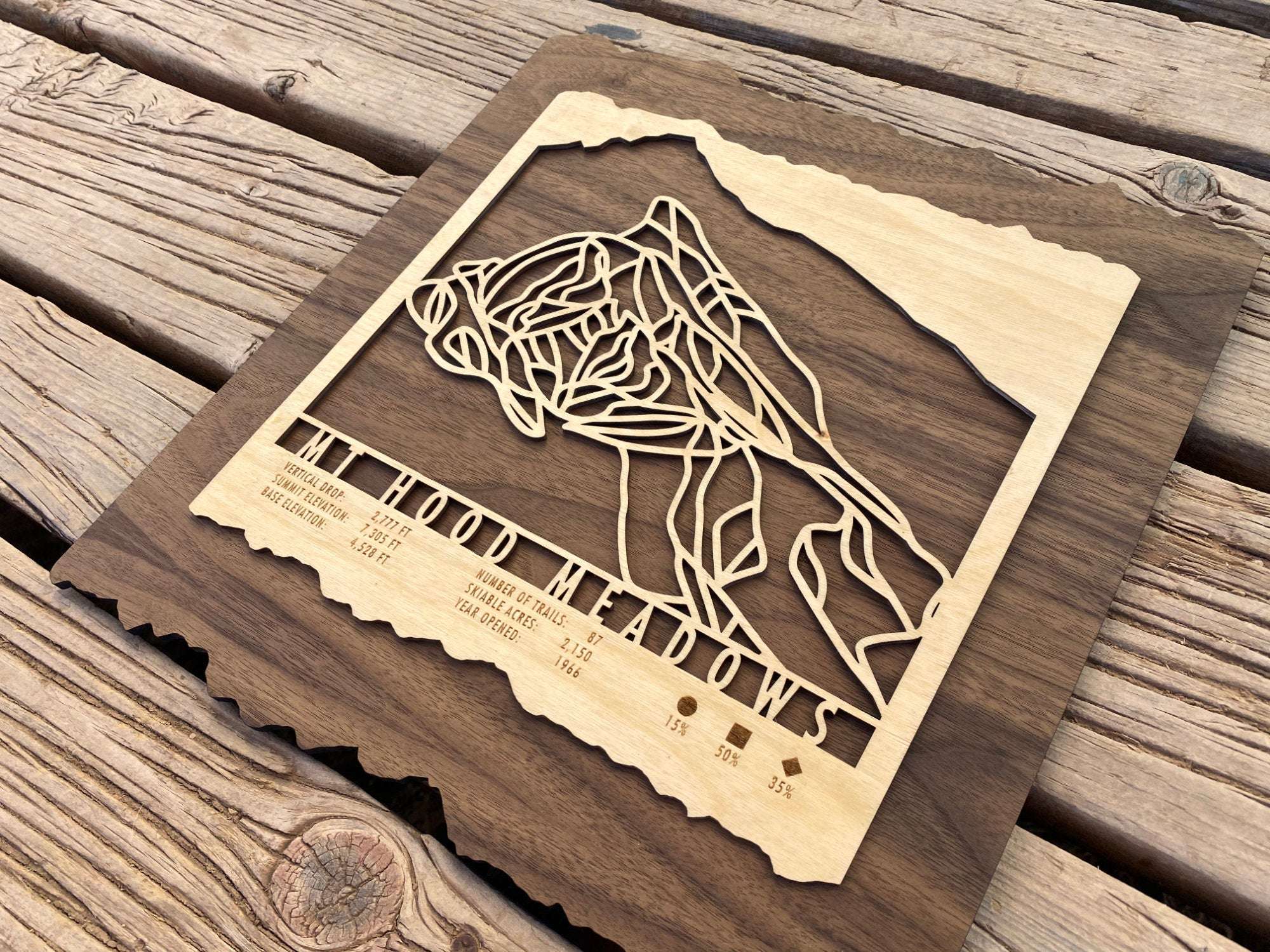 Angled view of Mt Hood Meadows Ski Trail Map wood wall art with intricate trail lines and engraved resort information, ideal for ski enthusiasts.