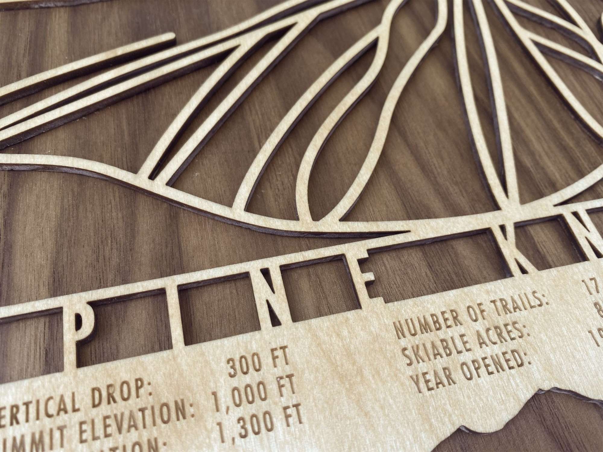 Close-up of Pine Knob Ski Trail Map - Wood Ski Decor - Mountaincut highlighting precision-cut trails and engraved elevation and trail data. Unique ski-themed wall art.