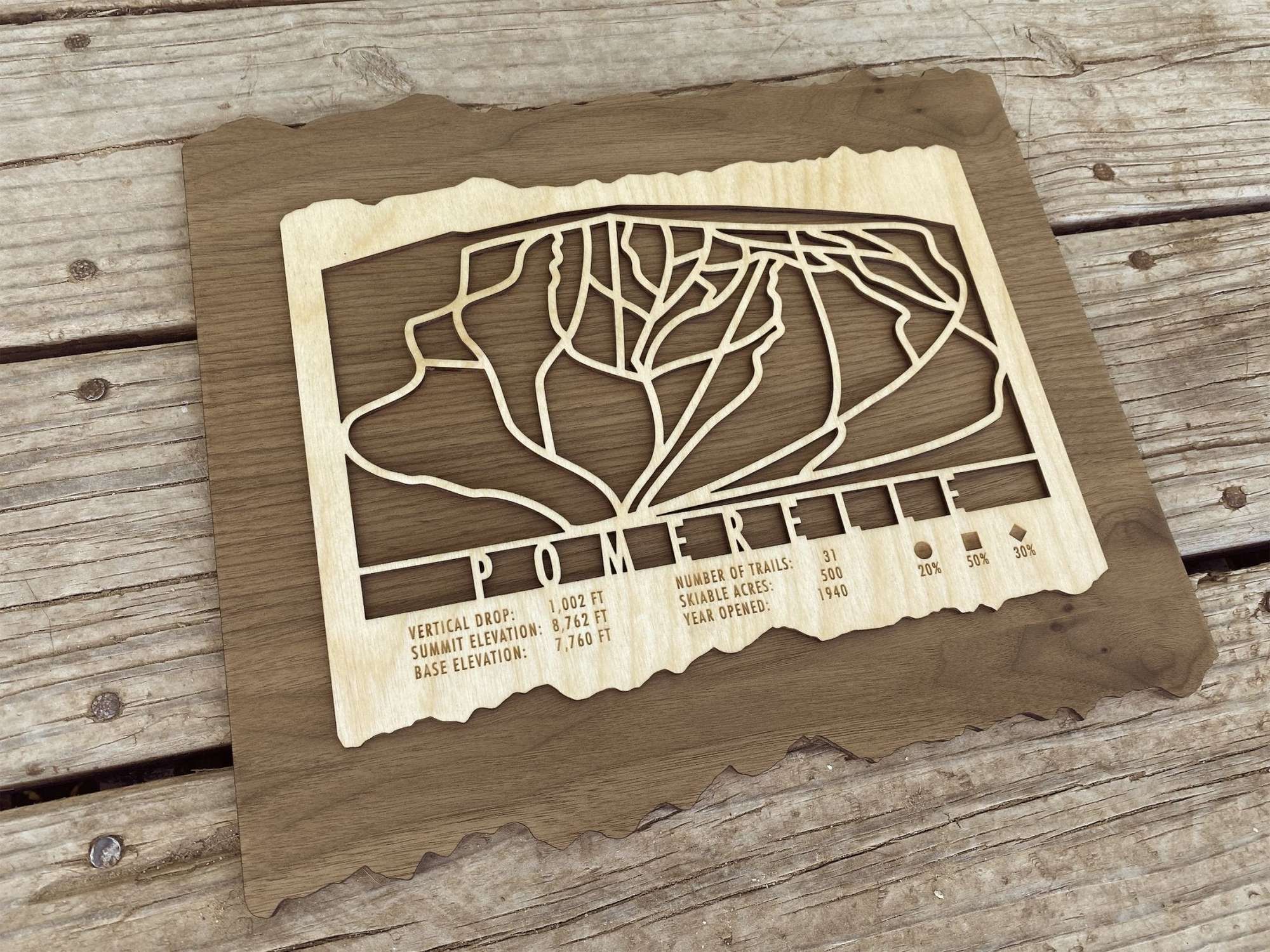 Wooden Pomerelle Ski Trail Map by Mountaincut displayed on rustic wood background, ideal ski-themed wall decor for cabins and ski homes.