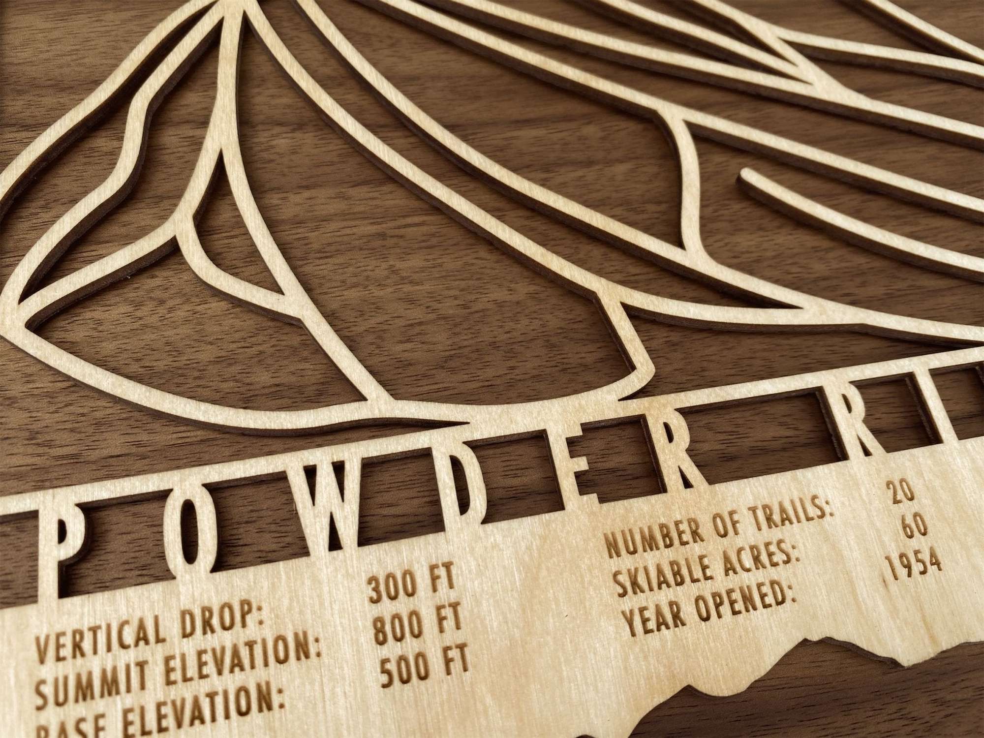 Close-up of Powder Ridge Minnesota wood ski map showing engraved trail lines and resort information for ski-themed wall art.