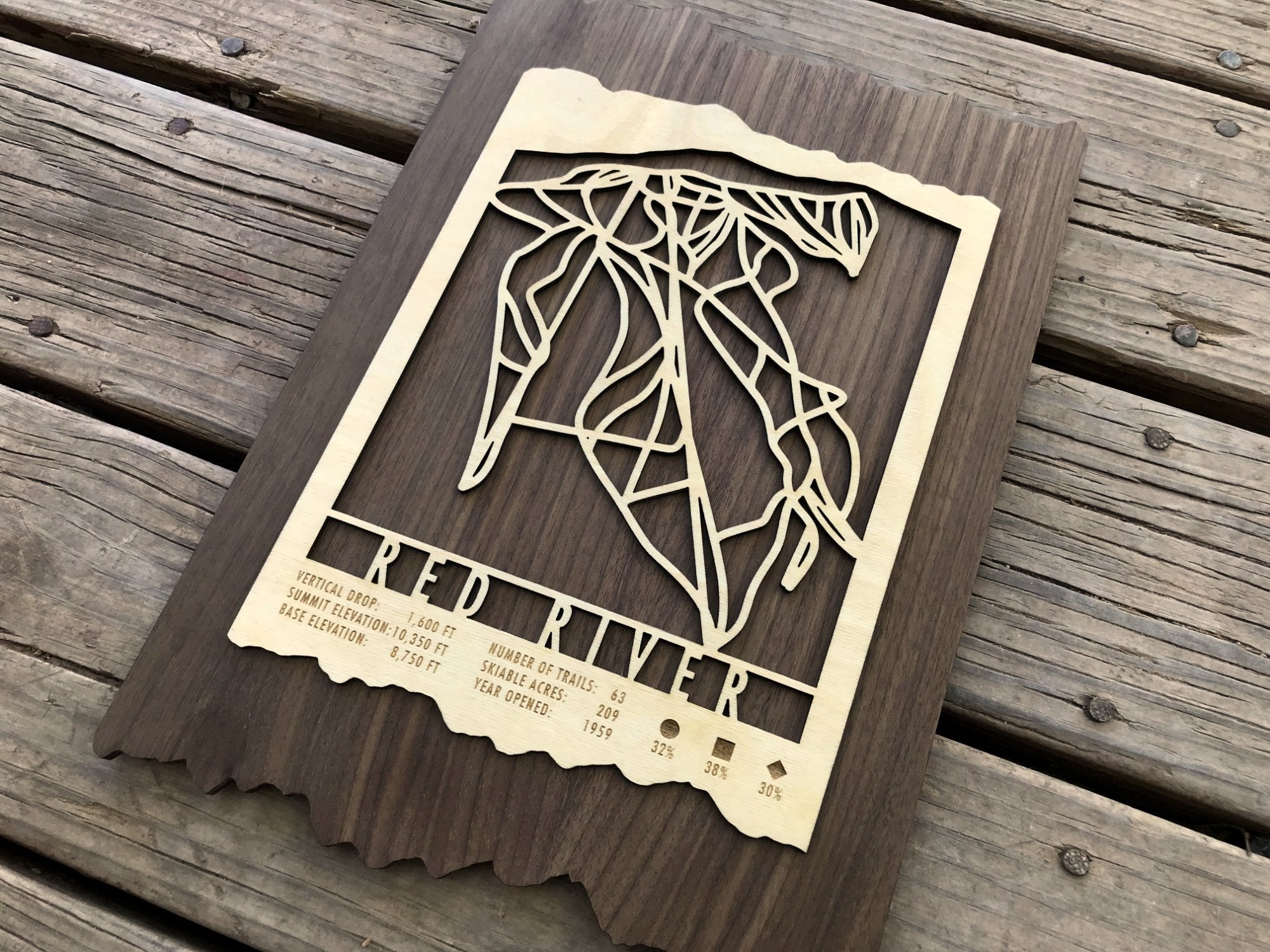 Close-up angled shot of Red River Ski Trail Map - Highlighting precision-cut ski trails and engraved resort stats on wood.
