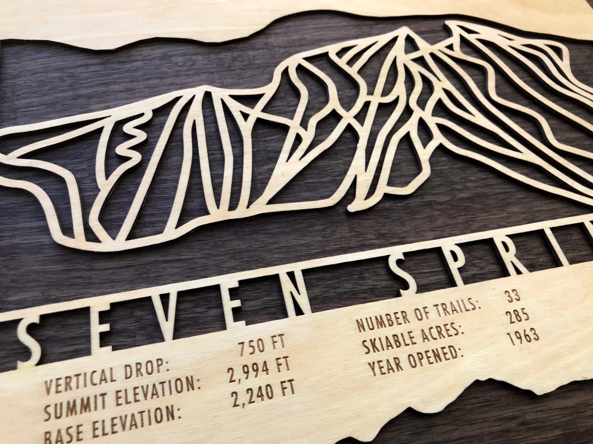 Close-up of Seven Springs Ski Trail Map - Wood Wall Decor showing detailed trail lines and engraved resort information on natural wood.
