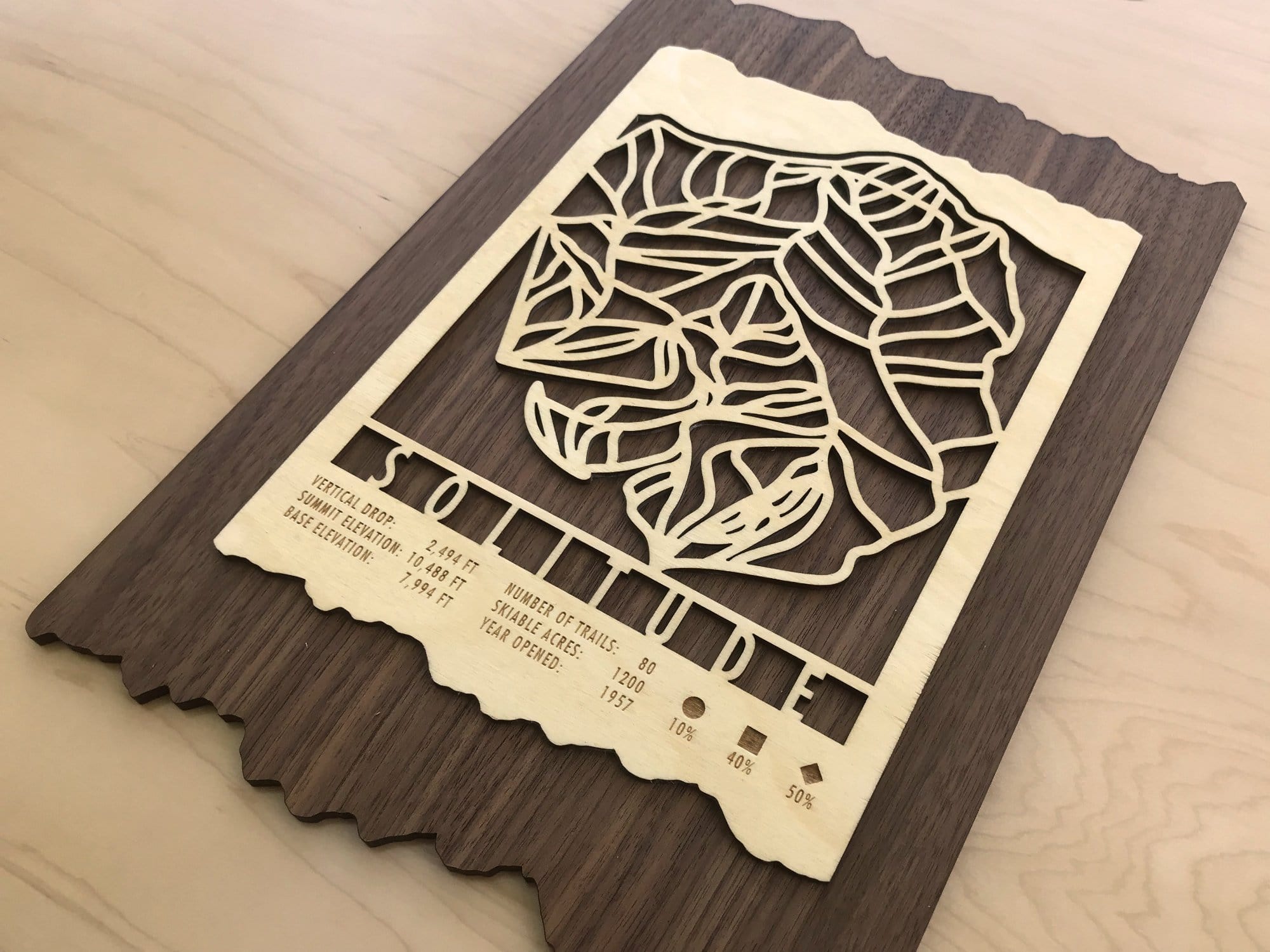 Angled view of Solitude Ski Trail Map - Wood Wall Decor showing intricate trail design and engraved resort stats, perfect for rustic ski-themed interiors.