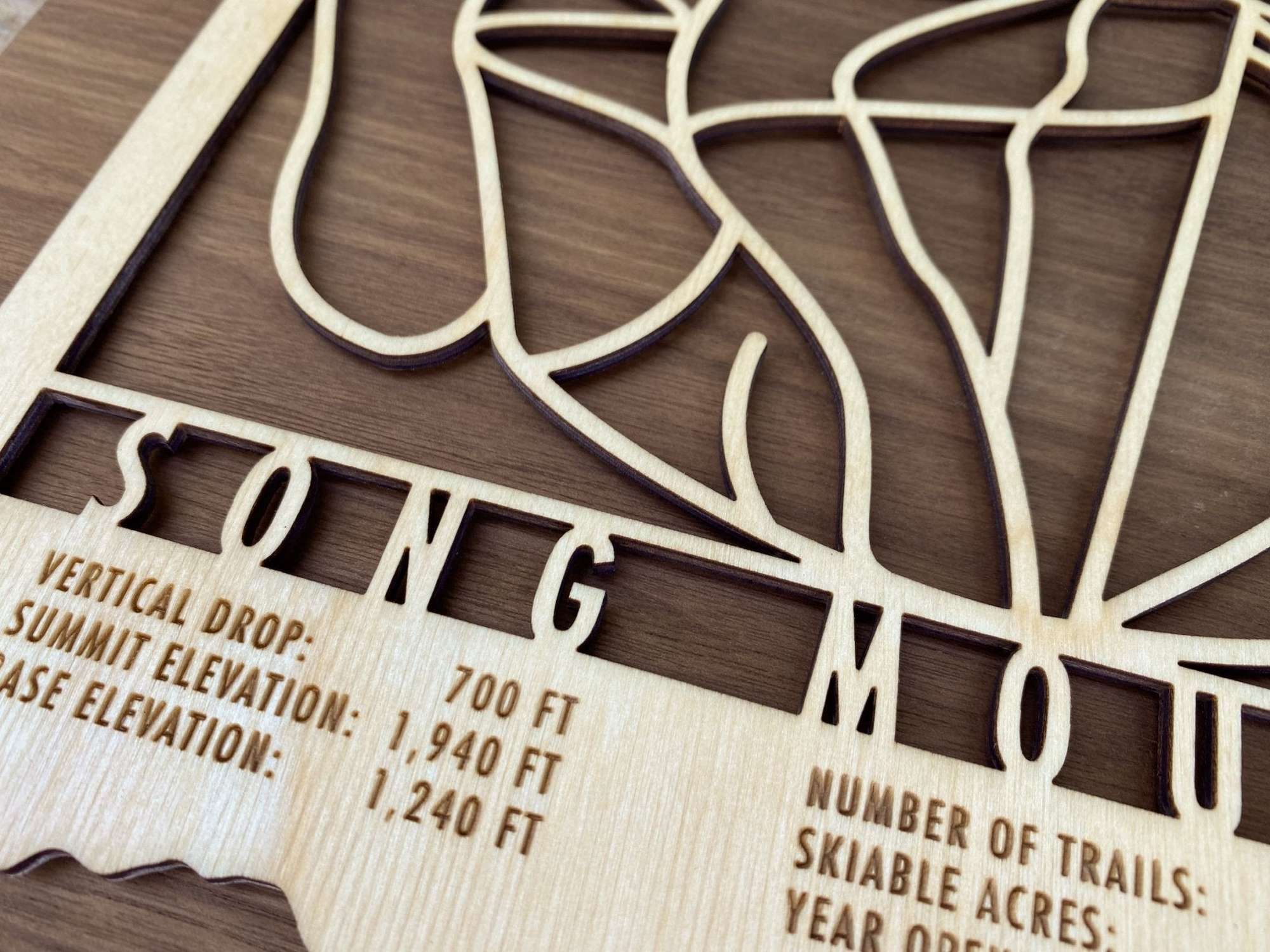 Close-up of Song Mountain Ski Trail Map - Wood Wall Decor highlighting precision laser-cut trails and engraved elevation and trail data of the New York ski area..