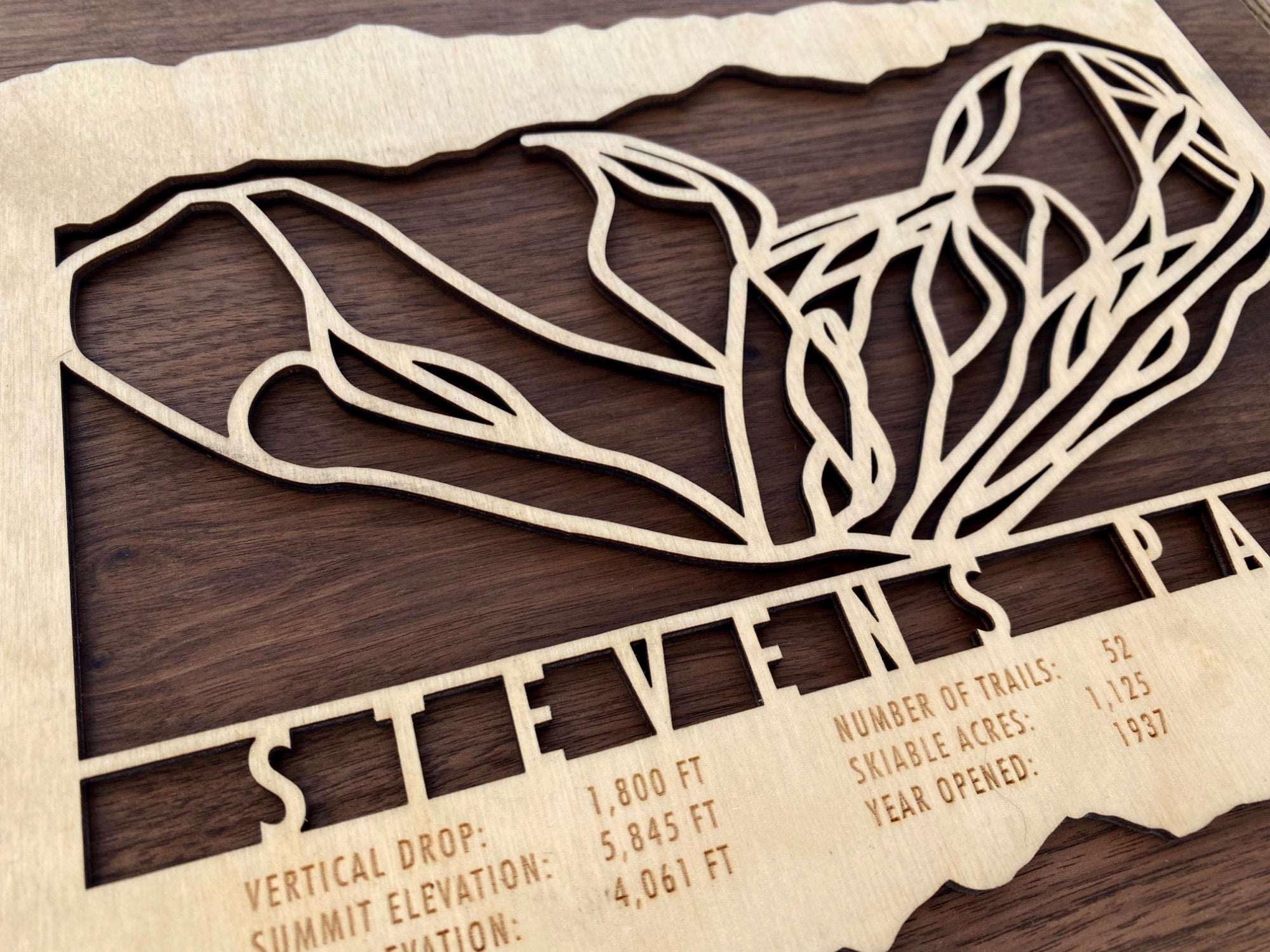 Detailed view of Stevens Pass wood ski map with engraved mountain stats of this Washington ski area.
