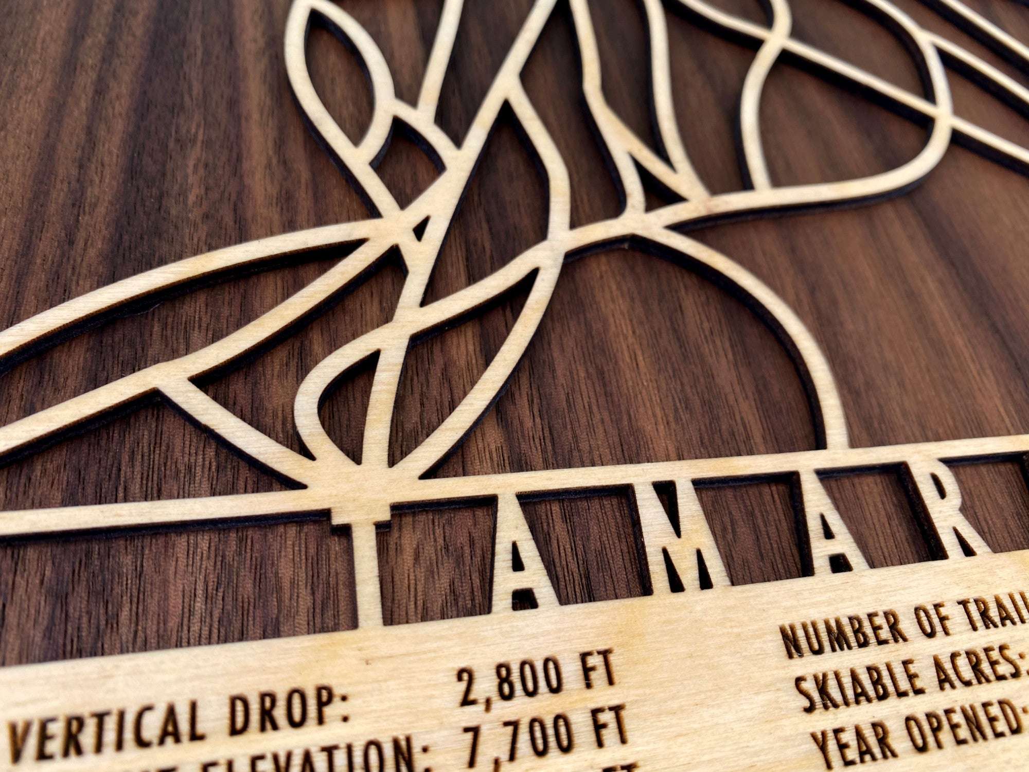 Close-up of Tamarack Ski Trail Map - Wood Ski Decor - Mountaincut showing intricate laser-cut trails and engraved resort stats of the Idaho ski resort.