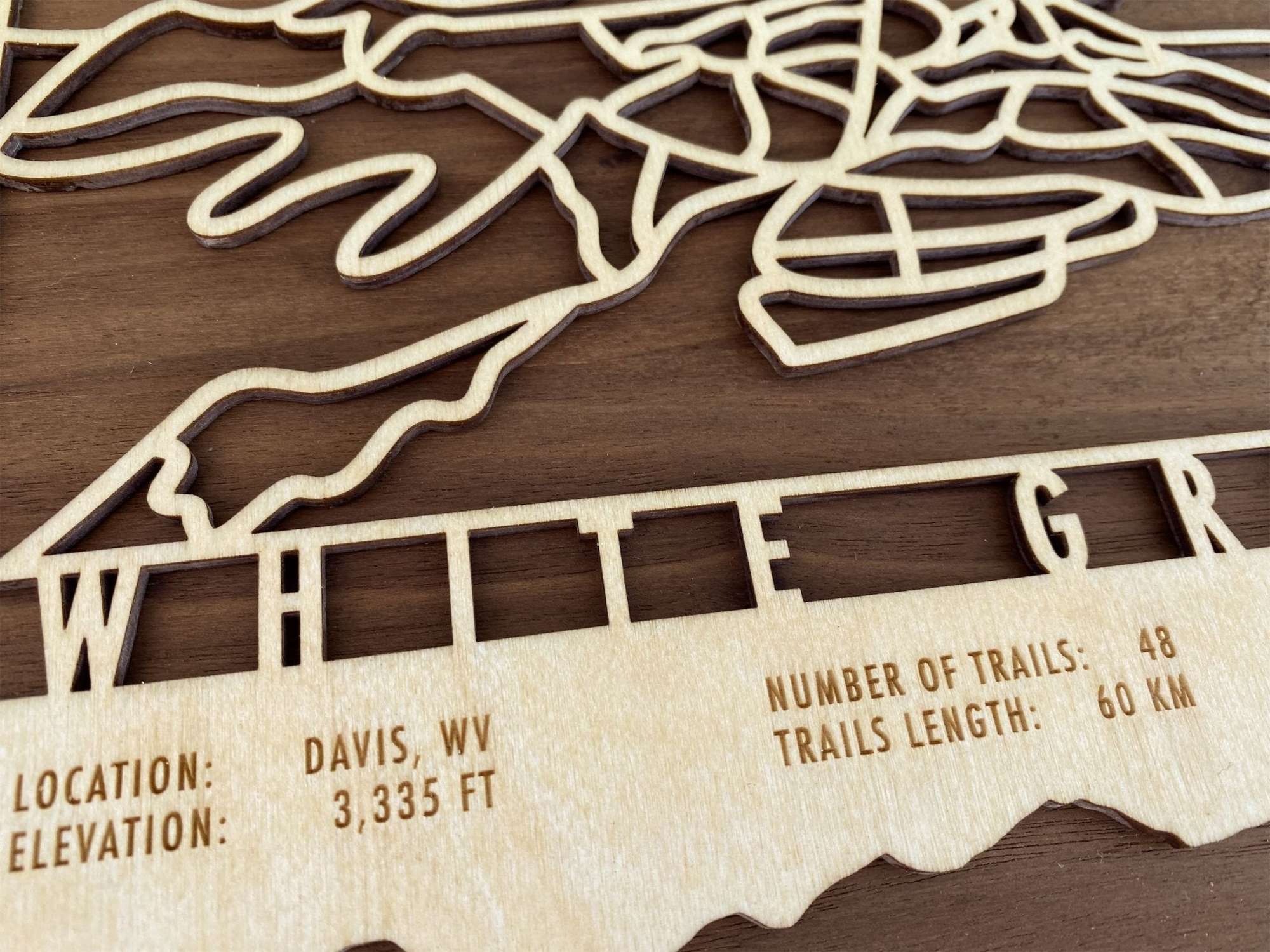 Close-up of White Grass wood ski trail map with engraved elevation, trail count, and difficulty stats, ideal for XC ski enthusiasts.
