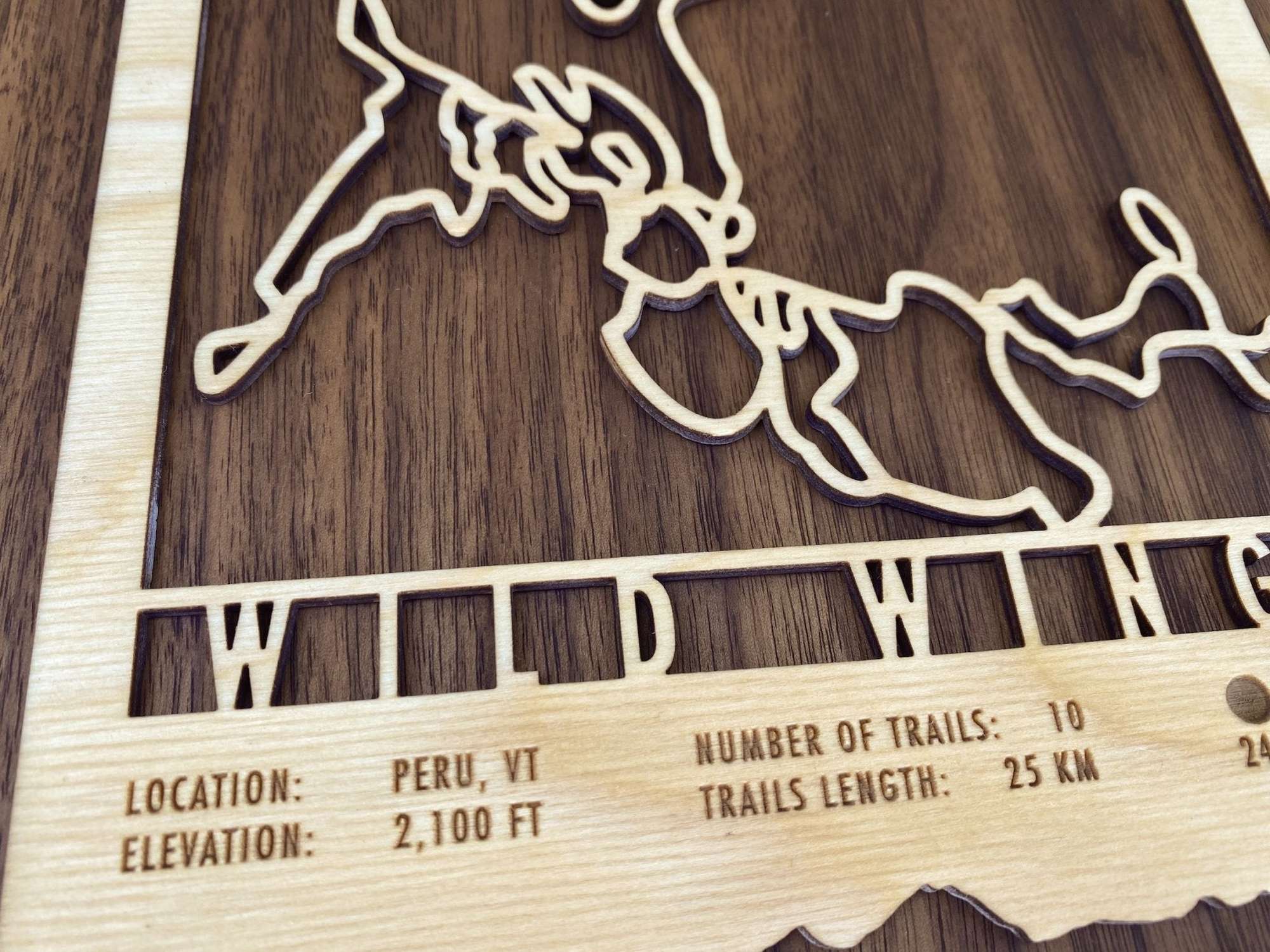 Detailed view of Wild Wings Trail Map - Ski Decor - Mountaincut showing Peru, VT location, elevation, and trail data etched into wood.