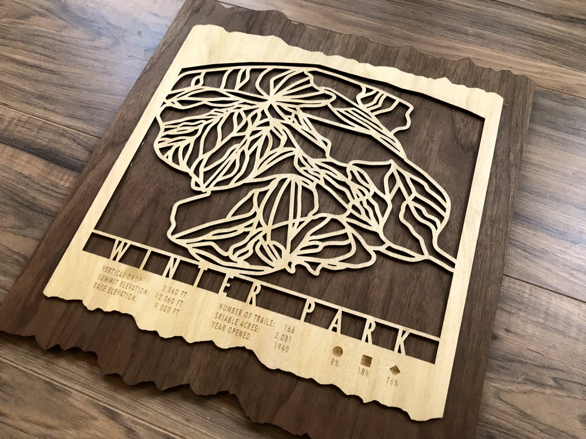 Angled view of Winter Park Ski Trail Map - Wood Ski Decor - showing detailed wood trail map and engraved mountain stats.