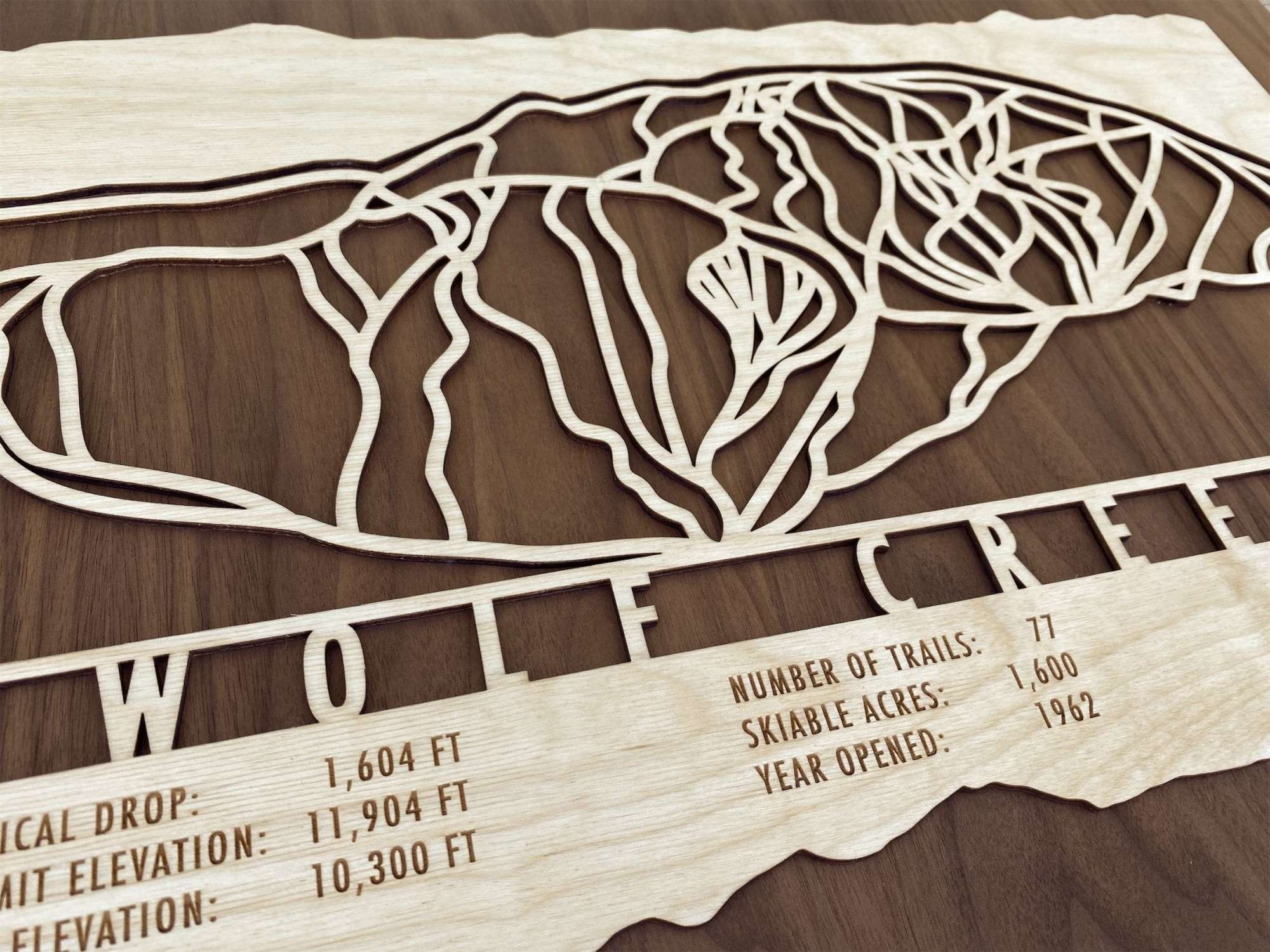 Close-up of Wolf Creek ski map wood wall art showing engraved trail lines and resort statistics, perfect for ski lovers and Colorado decor themes.