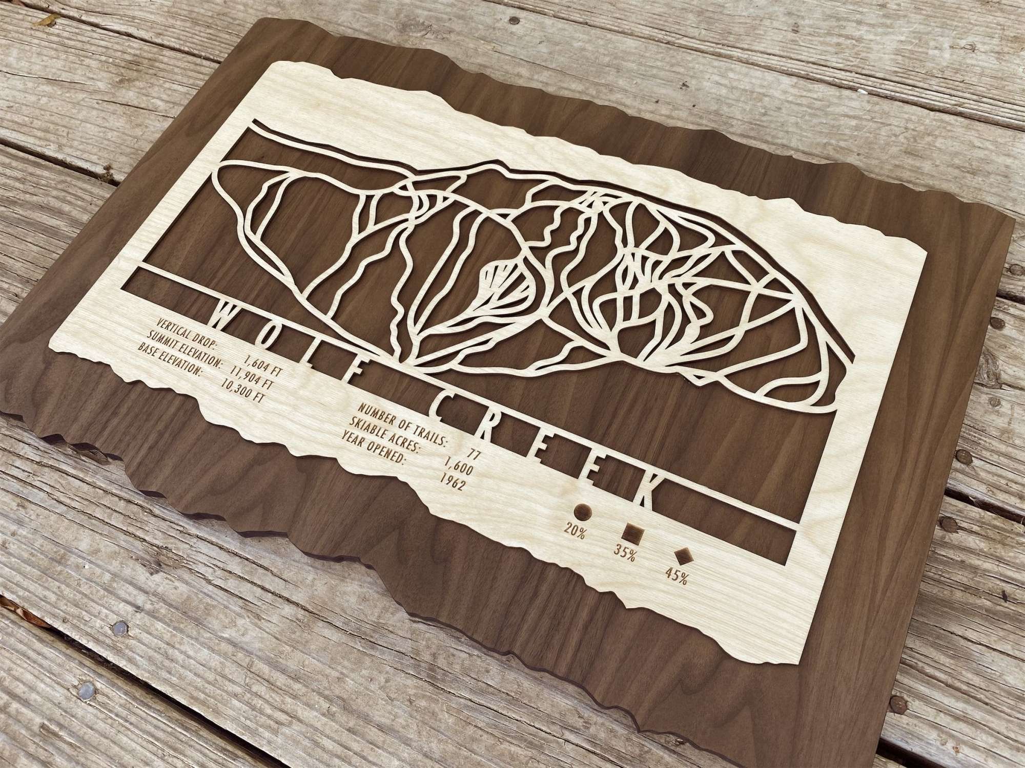 Angled view of Wolf Creek Ski Trail Map - Wood Ski Decor - Mountaincut showing intricate trail carvings and engraved resort details on layered wood.
